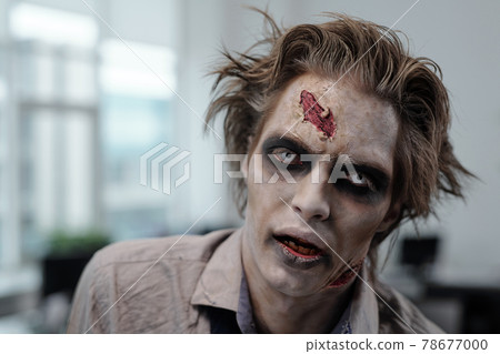 Male zombie with stage makeup on face 78677000