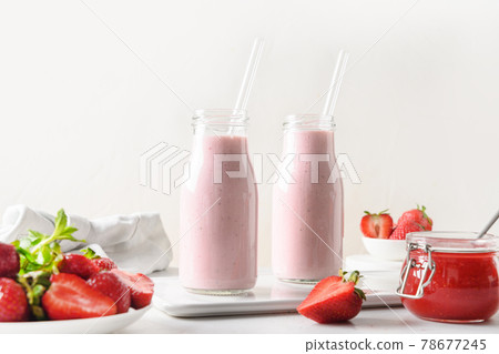 Indian strawberry lassi or milkshake in bottle on white . 78677245