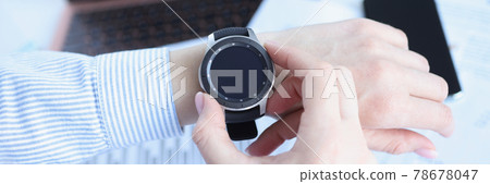 Woman looking at smart watch at workplace closeup Woman looking at smart watch at workplace closeup 78678047