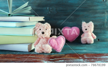 Teddy bears, a stack of books with bookmarks of flower buds, hearts on a wooden background, the concept of love, reading romantic literature Teddy bears, a stack of books with bookmarks of flower buds, hearts on a wooden background, the concept of love, reading romantic literature 78678199