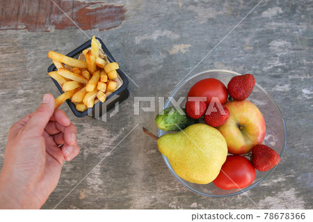 French fries, fruits, vegetables. Concept choosing correct nutrition or of junk eating.  78678366