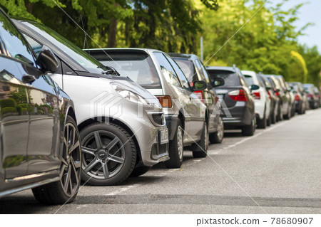 Rows of cars parked on the roadside in residential district. Small car parked between other cars. Rows of cars parked on the roadside in residential district. Small car parked between other cars. 78680907