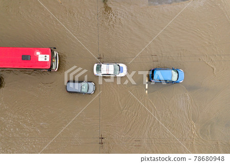 Aerial view of traffic cars driving on flooded road with rain water. 78680948