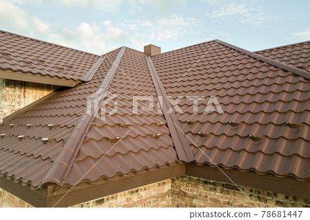 Detail of house roof structure covered with brown metal tile sheets. 78681447