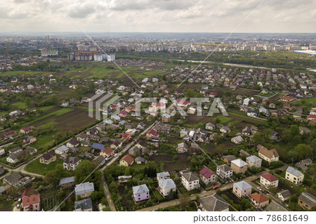 Aerial landscape of small town or village with rows of residential homes and green trees. 78681649