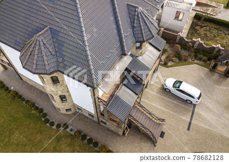New expensive white car parked in paved well-kept yard with green lawn, decorative bushes and brick fence of big two story house. Luxury and prosperity concept. 78682128