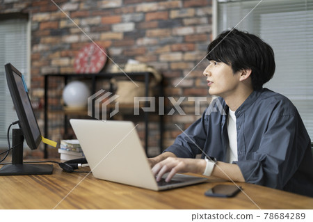 A young man working on a personal computer A young man working on a personal computer 78684289