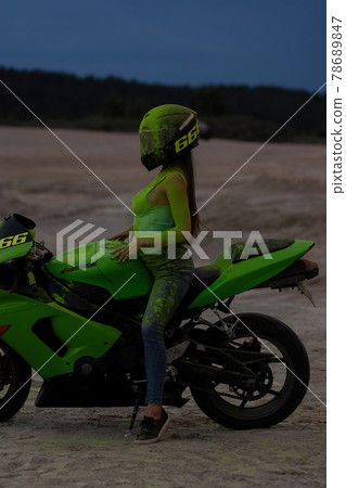 Unrecognizable woman on motorcycle at sunset Unrecognizable woman on motorcycle at sunset 78689847