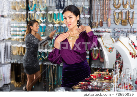 Asian woman looking for elegant necklace in bijouterie boutique Asian woman looking for elegant necklace in bijouterie boutique 78690059