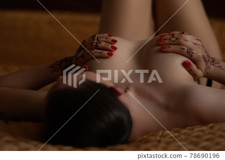 Sensual woman with mehndi lying in bed Sensual woman with mehndi lying in bed 78690196