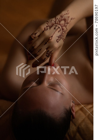 Sensual woman with mehndi lying in bed Sensual woman with mehndi lying in bed 78690197