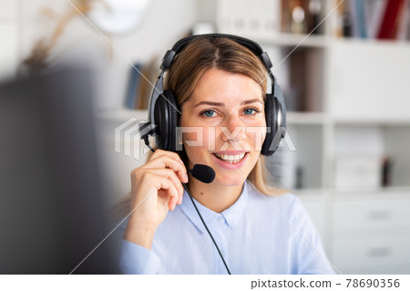 positive woman sitting with headphones in white room positive woman sitting with headphones in white room 78690356
