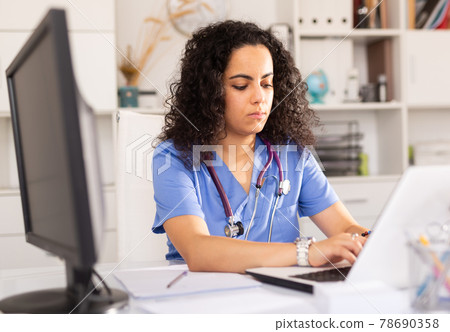 Female doctor working on laptop in office Female doctor working on laptop in office 78690358