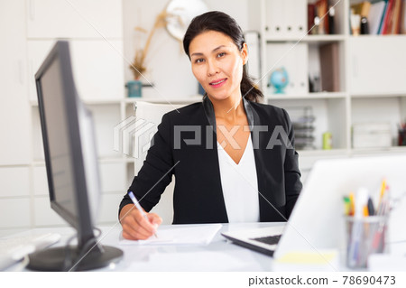 Adult business woman using laptop at workplace 78690473