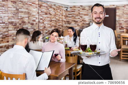 Waiter serving restaurant guests 78690656