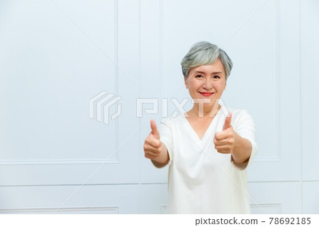 一位銀髮白髮的年長婦女在落地窗旁 一位銀髮白髮的年長婦女在落地窗旁 78692185
