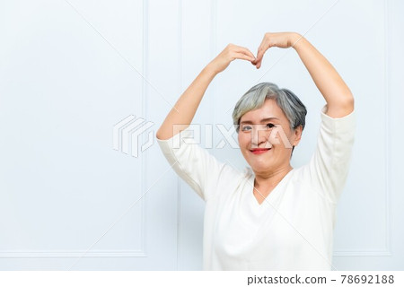 一位銀髮白髮的年長婦女在落地窗旁 78692188