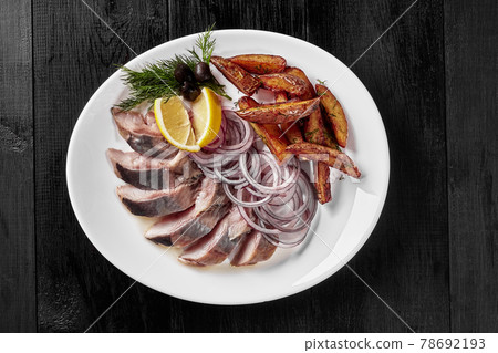 Salted herring with fried potato wedges, onion, lemon Salted herring with fried potato wedges, onion, lemon 78692193