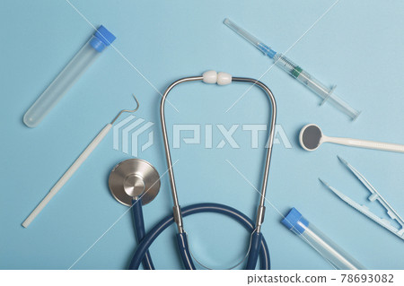 Medical instruments, devices and items on the colored table in the hospital. Syringe, test tube, tweezers. Healthcare, medicine, treatment and doctors concept Medical instruments, devices and items on the colored table in the hospital. Syringe, test tube, tweezers. Healthcare, medicine, treatment and doctors concept 78693082