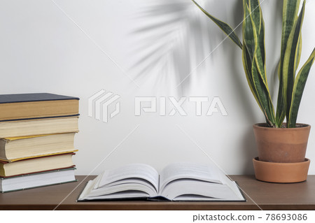 Book background. Open book on a table in a university or home desk and school library. Reading, literature, study and knowledge concept. 78693086