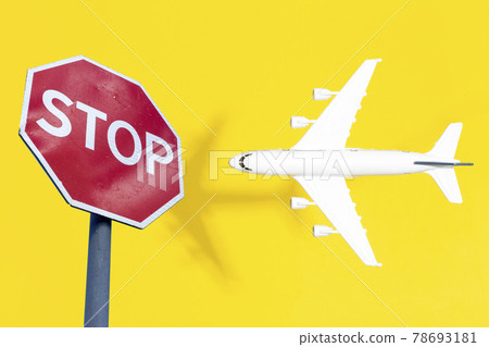 Flight ban and closed borders for tourists and travelers. No-fly zone concept. Airplane in flight with a STOP sign Flight ban and closed borders for tourists and travelers. No-fly zone concept. Airplane in flight with a STOP sign 78693181