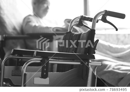 一位患有癡呆症的老婦人和輪椅在護理床上放鬆時玩著小毛巾 78693495