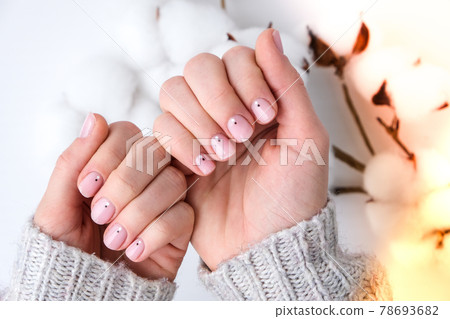 Woman hands with beautiful nude manicure holding delicate white cotton flower. Female Manicure, natural look. Nails care. Self care. 78693682