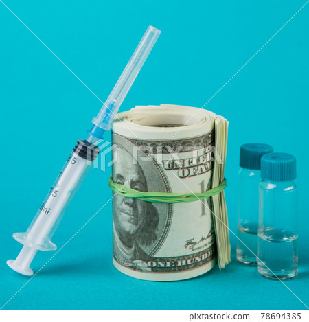 concept of financing and cash costs for universal vaccination, big roll of dollars, next to vaccine and syringe concept of financing and cash costs for universal vaccination, big roll of dollars, next to vaccine and syringe 78694385
