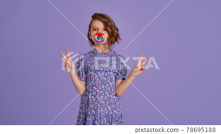 Teen age Girl in blue summer flower print dress holding pop it antistress toy on lavender background, isolate.  78695188