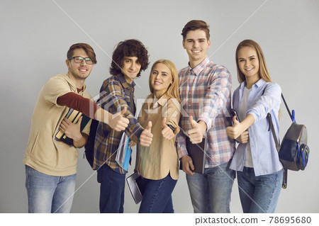 Happy smiling teen students showing thumbs up approve gesture isolated portrait 78695680
