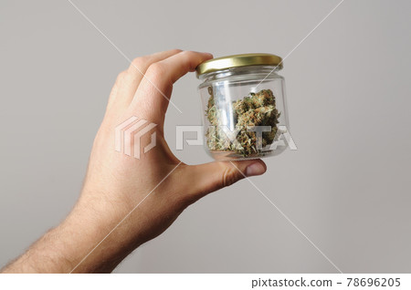 Cannabis buds in storage jar. Medicinal marijuana usage. 78696205