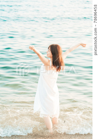 One-piece woman entering the sea 78696458