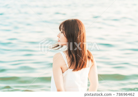 One-piece woman entering the sea 78696462