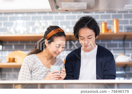 A couple smiling in the kitchen A couple smiling in the kitchen 78696579
