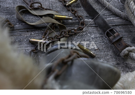 Bullet caings and rusy chain resting on wooden table Bullet caings and rusy chain resting on wooden table 78696580