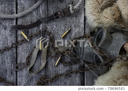 Bullet caings and rusy chain resting on wooden table Bullet caings and rusy chain resting on wooden table 78696581