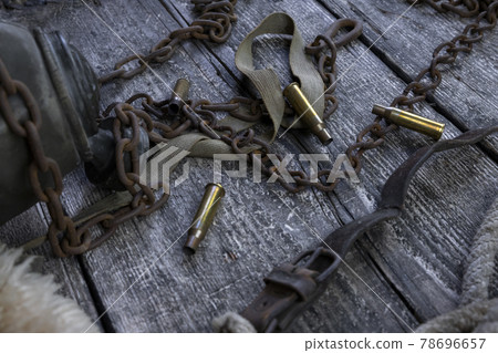 Bullet caings and rusy chain resting on wooden table Bullet caings and rusy chain resting on wooden table 78696657