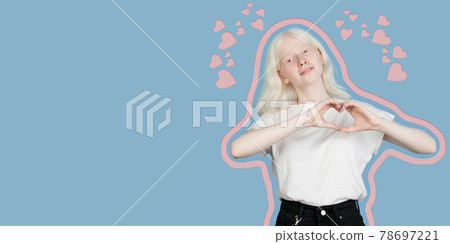 Smiling young girl showing heart with two hands, love sign. Isolated over blue background. 78697221