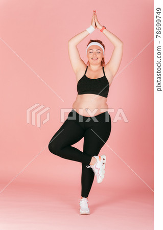 Young plus size woman practicing yoga 78699749