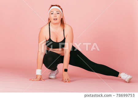 Full length portrait of plump woman doing physical exercise 78699753