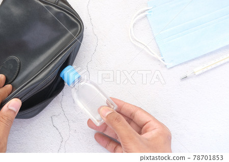 man hand putting hand sanitizer in small bag man hand putting hand sanitizer in small bag 78701853