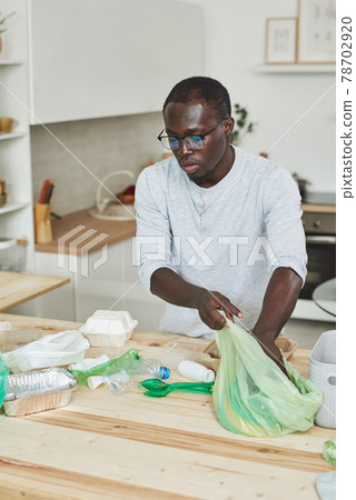 Man sorting the rubbish at home Man sorting the rubbish at home 78702920