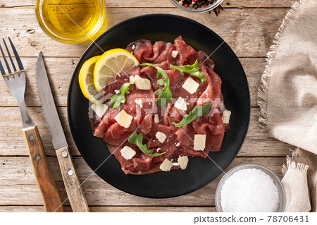Marbled beef carpaccio on black plate 78706431