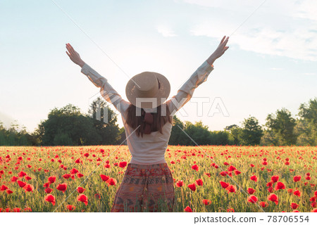 Young woman dancing on poppy field from back Young woman dancing on poppy field from back 78706554
