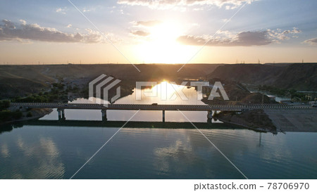 Sunset with a view of the dam and bridge. 78706970