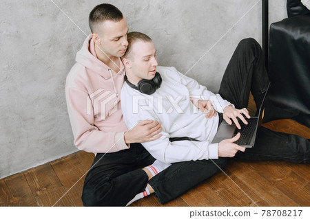 Gay couple consulting their travel plans together with a laptop Gay couple consulting their travel plans together with a laptop 78708217