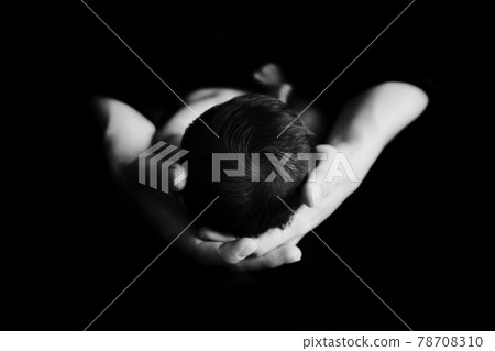 在黑暗的房間裡拍攝的可愛可愛的小新生嬰兒頭部的黑白照片 78708310