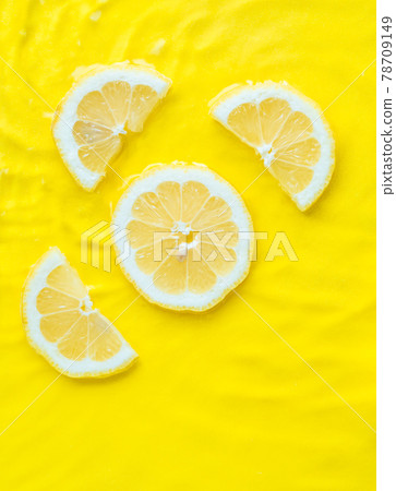 Intense yellow lemon citrus slice in water with ripples texture summer background Intense yellow lemon citrus slice in water with ripples texture summer background 78709149