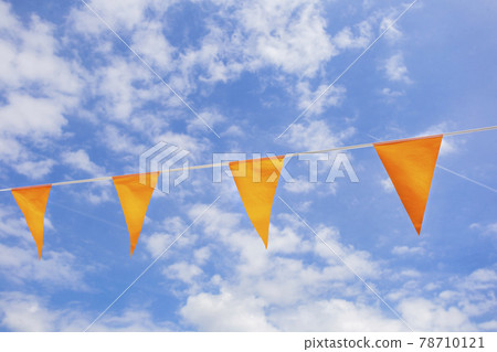 Flags in Dutch national color orange in the clear blue sky with sunlight for celebrating kings Day or EUFA Euro, World Championship support national soccer team 78710121