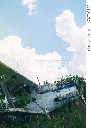 Close-up of a crashed airplane wing. The metal frame and internal parts are visible. Pieces of upholstery and fabric upholstery blow in the wind. Rust and debris Close-up of a crashed airplane wing. The metal frame and internal parts are visible. Pieces of upholstery and fabric upholstery blow in the wind. Rust and debris 78710163